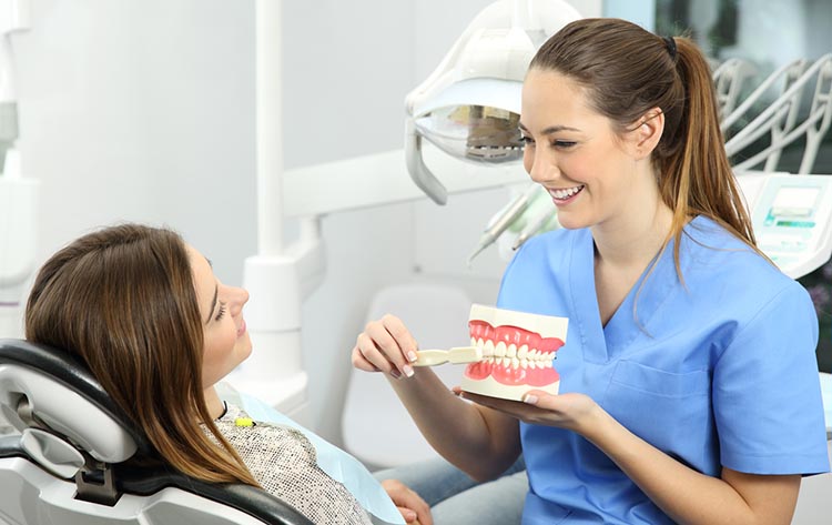 Dentist explaining how to brush teeth